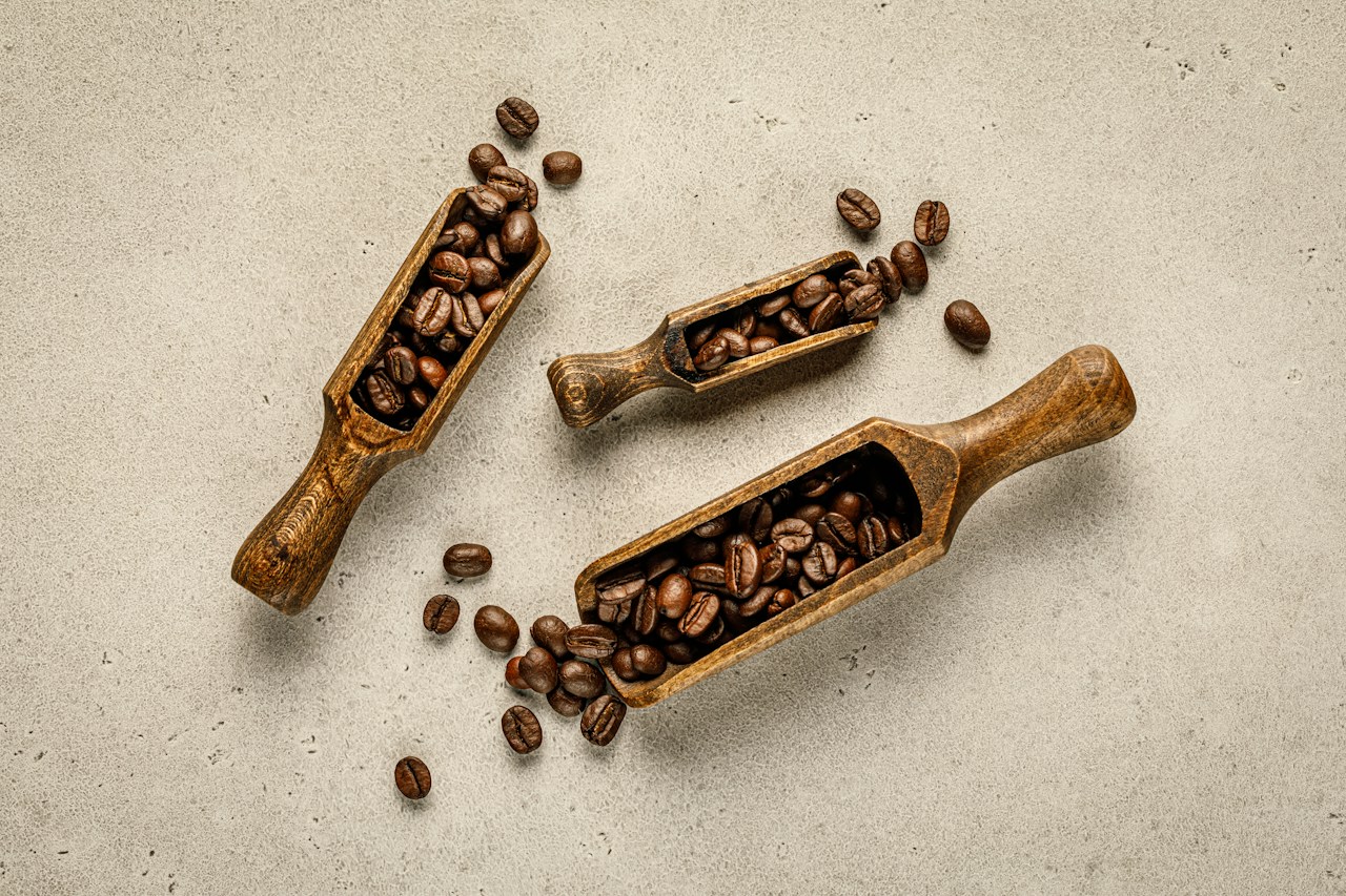 Dua sendok kayu berisi biji kopi sangrai beraneka karakter rasa